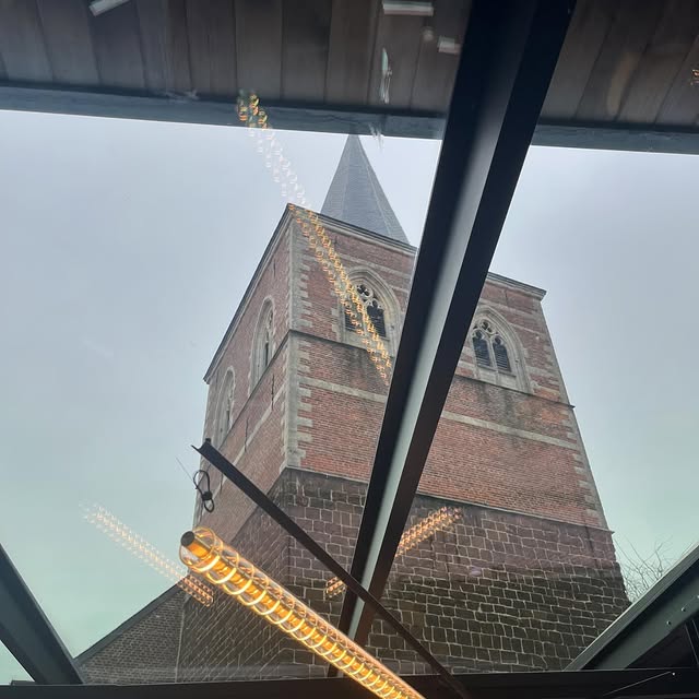 Helder gereinigd glazen dak met uitzicht op een kerktoren